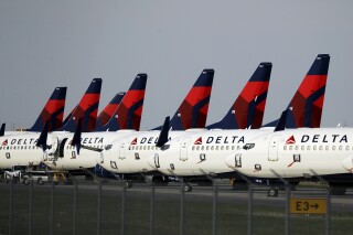 FILE - In this April 1, 2020, file photo, several dozen Delta Air Lines jets are parked at Kansas City International Airport in Kansas City, Mo. Delta is backtracking slightly on changes it previously announced in its frequent-flyer program, but it still plans to reshape SkyMiles to favor big spenders over customers who take the most flights. Delta outlined the revisions in an email from CEO Ed Bastian to SkyMiles members on Wednesday, Oct. 18, 2023. (AP Photo/Charlie Riedel, File)