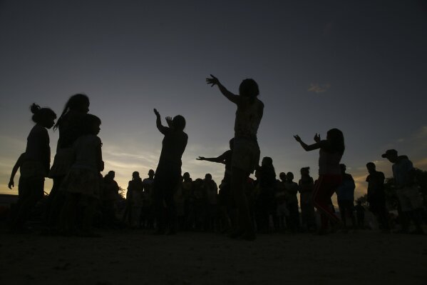 
              In this March 10, 2018 photo, Warao women dance in the outdoor area of a shelter in Pacaraima, the main entry point for Venezuelans in the Brazilian northern state Roraima. Despite the difficulties and an uncertain future, many Warao say they are happy to be in Brazil, even going so far as to call the shelter a "paradise" compared to what they left behind. (AP Photo/Eraldo Peres)
            
