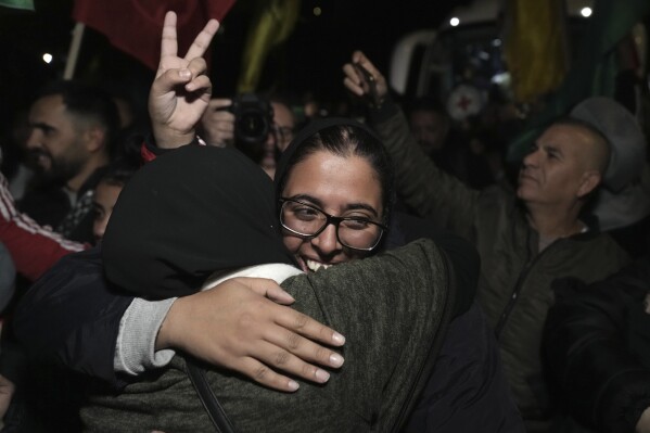 Palestinian Fairuze Salameh is greeted after she was released from prison by Israel, in the West Bank town of Ramallah, early Wednesday Nov. 29, 2023. Hamas and Israel released more hostages and prisoners under terms of a fragile cease-fire that held for a fifth day Tuesday. (AP Photo/Nasser Nasser)