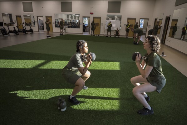 Two female U.S. Marine Corps recruits with Romeo company take part in physical therapy exercises at the rehabilitation center after sustaining injuries during training at the Marine Corps Recruit Depot, Wednesday, June 28, 2023, in Parris Island, S.C. (AP Photo/Stephen B. Morton)