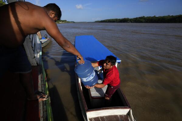 Gallons of water for human consumption are transported on passenger boats to serve communities located on the islands of the Bailique Archipelago in the district of Macapa, state of Amapa, northern Brazil, Saturday, Sept. 10, 2022. The Amazon River discharges one-fifth of all the world’s freshwater that runs off land surface. Despite that force, the seawater pushed back the river that bathes the archipelago for most of the second half of 2021, leaving thousands scrambling for drinking water. (AP Photo/Eraldo Peres)