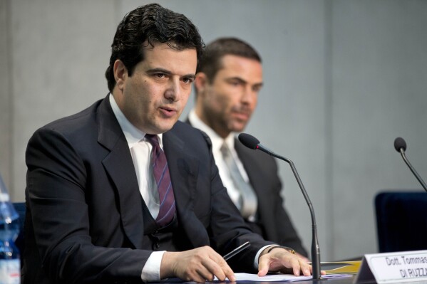 FILE- Tommaso Di Ruzza, then director of the Vatican Financial Information Authority, left, flanked by Rene Brulhart, then president of the AIF, April 28, 2016, during a hearing. Two Vatican trials are coming to a head and posing uncomfortable questions for the Holy See, given they both underscore Pope Francis’ absolute power and the legal, financial and reputational problems that can arise when he wields it. (AP Photo/Andrew Medichini, file)