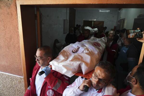 Mourners carry the bodies of 8 Red Crescent emergency responders, recovered in Rafah a week after an Israeli attack, as they are transported for burial from a hospital in Deir al-Balah, Gaza Strip, on Monday, March 31, 2025. (AP Photo/Abdel Kareem Hana)