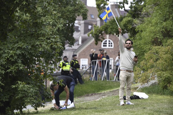 FILE - Protestor Salwan Momika waves the Swedish flag outside the Iraqi embassy in Stockholm, on July 20, 2023, where he plans to burn a copy of the Quran and the Iraqi flag. Momika, an Iraqi man who carried out several Quran burnings in Sweden told a newspaper on Wednesday March 27, 2024 that he would seek asylum in neighboring Norway in the wake of a deportation order by authorities in Stockholm. (Oscar Olsson/TT via AP, File)