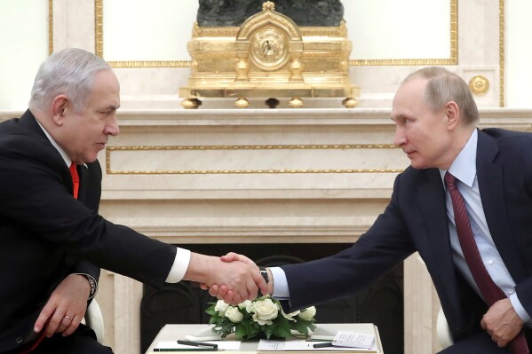 FILE - Russian President Vladimir Putin, right, shakes hands with Israeli Prime Minister Benjamin Netanyahu during their meeting in the Kremlin in Moscow, Russia, Thursday, Jan. 30, 2020. Russia and Israel have steadily expanded trade and other contacts and strengthened security ties, and Moscow has been guarded in commenting on the Gaza fighting. (Maxim Shemetov/Pool Photo via AP, File)