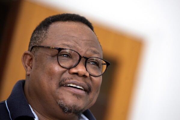 FILE - Exiled Tanzanian opposition leader Tundu Lissu gives an interview to The Associated Press in Tienen, Belgium on Friday, March 19, 2021. Tanzania's opposition leader Tundu Lissu was on Sunday arrested and later released on bail by the police who accused him of unlawful assembly and obstructing police officers. Lissu was earlier barred from attending a human rights rally in Ngorongoro, in the north of the country. In speeches at other political rallies, he had been critical of the government's new port deal with a Dubai-based company. (AP Photo/Virginia Mayo, File)