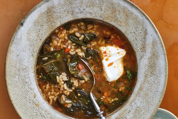 This image provided by Beatriz da Costa shows collard greens and rice soup, a recipe from "The Simple Art of Rice: Recipes from Around the World for the Heart of Your Table," a book by chef JJ Johnson and Danica Novgorodoff. (Beatriz da Costa via AP)