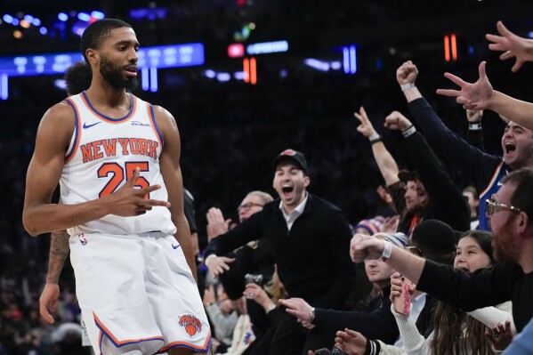New York Knicks' Mikal Bridges, left, and fans react after Bridges hit a three point basket during the second half of an NBA basketball game, Wednesday, Dec. 25, 2024, in New York. The Knicks defeated the Spurs 117-114. (AP Photo/Seth Wenig)