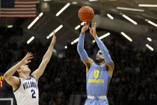 Marquette's Markus Howard (0) goes up for a shot against Villanova's Collin Gillespie (2) during the first half of an NCAA college basketball game Wednesday, Feb. 12, 2020, in Villanova, Pa. (AP Photo/Matt Slocum)