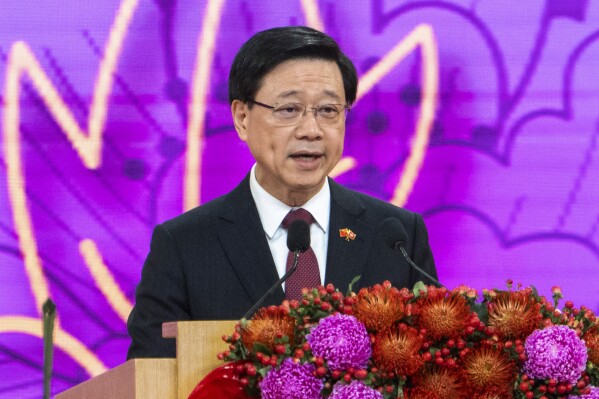 FILE - Hong Kong Chief Executive John Lee speaks at a reception following a flag raising ceremony for the celebration of 74th National Day of the People's Republic of China at the Golden Bauhinia Square in Hong Kong on Oct. 1, 2023. Hong Kong's leader on Tuesday, May 14, 2024, urged foreign governments to respect the duties of its overseas-based trade offices after a staff member in its London branch was charged in Britain for allegedly helping the city's intelligence service gather information. (AP Photo/Chan Long Hei, File)