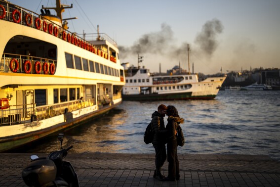 A couple kiss at Karakoy ferry terminal at the Bosphorus in Istanbul, Turkey, Tuesday, Feb. 27, 2024. (AP Photo/Francisco Seco)