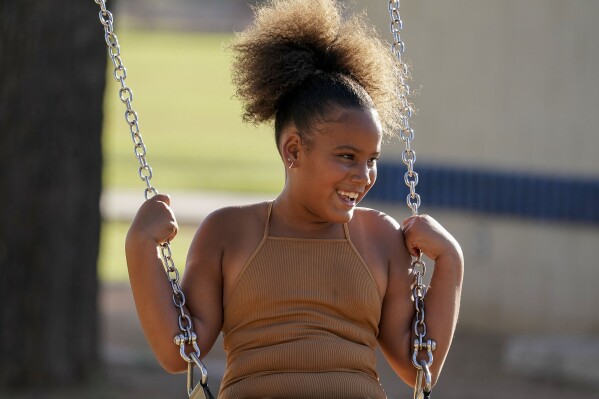 Aaliyah Ibarra swings at a park in Chandler Friday, June 16, 2023. By the time Aaliyah started second grade, her family had moved five times in four years in search of stable housing. As she was about to start a new school, her mother, saw how much it was affecting her education. (AP Photo/Darryl Webb)