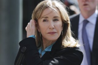 FILE - In this April 3, 2019 file photo, actress Felicity Huffman arrives at federal court in Boston to face charges in a nationwide college admissions bribery scandal.  Huffman's co-stars in a new Netflix movie say they found her remorseful about her role in a college admissions scandal.  Huffman didn't meet reporters to promote the film "Otherhood," which premieres on Netflix on Aug. 2. She pleaded guilty in May to paying $15,000 to a college admissions consultant to have a procter correct her daughter's answers on the SAT. (AP Photo/Charles Krupa, File)