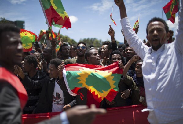 FILE - In this Saturday, Sept. 15, 2018 file photo, a man holds an Oromo Liberation Front (OLF) flag as hundreds of thousands of Ethiopians gathered to welcome returning leaders of the once-banned group in the capital Addis Ababa, Ethiopia. A new report by the rights group Amnesty International issued Friday, May 29, 2020 accuses Ethiopia's security forces of extrajudicial killings and mass detentions in the restive Oromia region even as the country's reformist prime minister was awarded the Nobel Peace Prize. (AP Photo/Mulugeta Ayene, File)