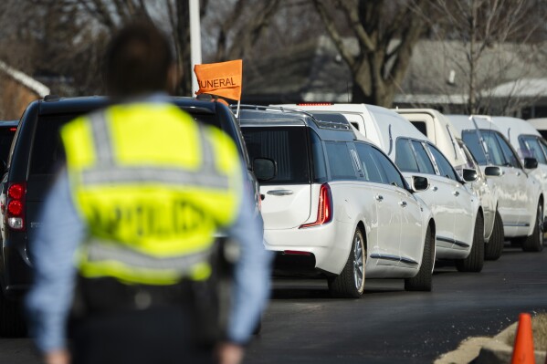 The hearses for Christine and William Esters, Tameaka, Joshua, Alexandria, Alonnah and Angel Nance are driven out of Victory City Church's parking lot in Joliet, Ill. after the funeral, Saturday, Feb. 3, 2024. Romeo Nance killed all seven of his relatives and another victim, which police believe to be random, on January 21 before killing himself on January 22 in Texas, according to Joliet police. (Pat Nabong/Chicago Sun-Times via AP)