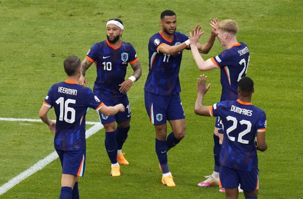 Cody Gakpo of the Netherlands, centre, scores his side's equalizing goal during a Group D match between Poland and the Netherlands at the Euro 2024 soccer tournament in Hamburg, Germany, Sunday, June 16, 2024. (AP Photo/Petr Josek)