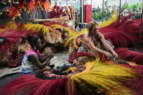Transgender women Negriny Venture, left, and Leticia Mamede prepare Carnival costumes for the Paraiso de Tuiuti samba school in Rio de Janeiro, Wednesday, Feb. 12, 2025. (AP Photo/Silvia Izquierdo)