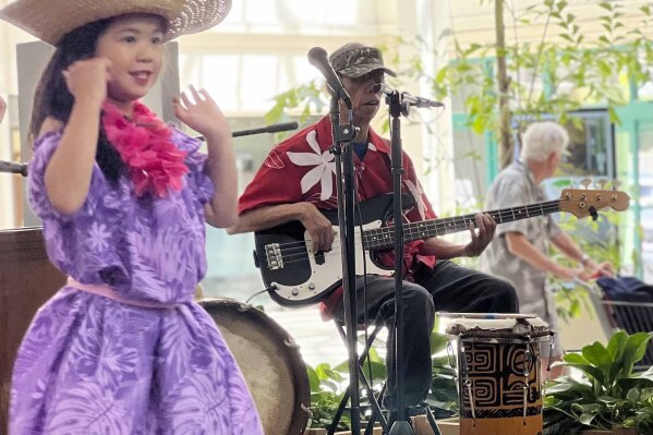 Buddy Jantoc, center, plays guitar at a hula show at the Lahaina Cannery in Lahaina, Hawaii, on April 23, 2023. (Agnes Dinh via AP)
