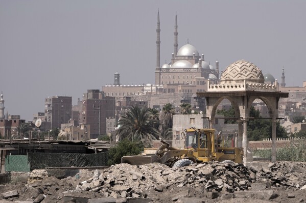 A bulldozer demolishes structures in Cairo's historic City of the Dead, Egypt, Saturday, Aug. 26, 2023. Authorities have already razed hundreds of tombs and mausoleums as they carry out plans to build a network of multilane highways through the City of the Dead, a vast cemetery in the Egyptian capital that has been in use for more than a millennium. (AP Photo/Amr Nabil)