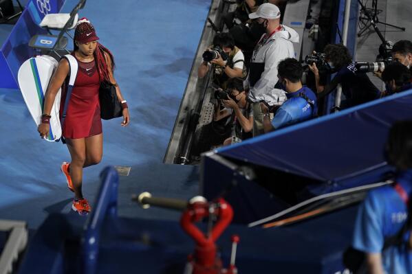 Naomi Osaka, of Japan, leaves center court after being defeated by Marketa Vondrousova, of the Czech Republic, during the third round of the tennis competition at the 2020 Summer Olympics, Tuesday, July 27, 2021, in Tokyo, Japan. (AP Photo/Seth Wenig)