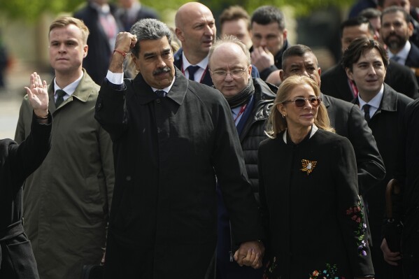 Venezuela's President Nicolas Maduro gestures as he walks with his wife Cilia Flores in Red square after the Victory Day military parade in Moscow, Russia, Friday, May 9, 2025, during celebrations of the 80th anniversary of the Soviet Union's victory over Nazi Germany during the World War II. (AP Photo/Pavel Bednyakov, Pool)