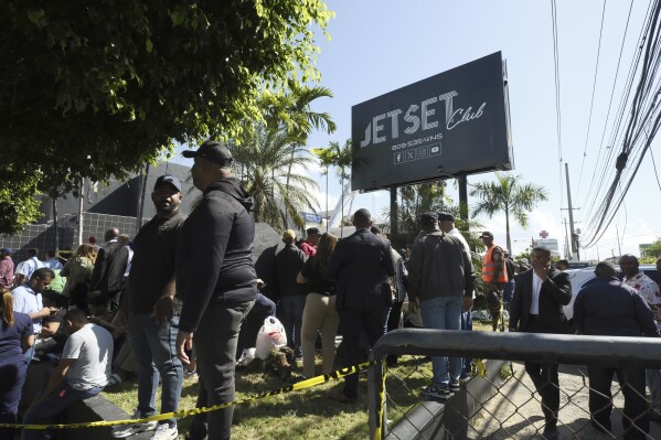 People gather outside the Jet Set nightclub after its roof collapsed during a merengue concert in Santo Domingo, Dominican Republic, Tuesday, April 8, 2025. (AP Photo/Ricardo Hernandez)