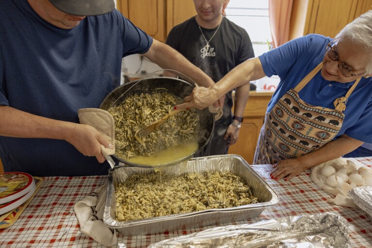 Members of the Springfield United Methodist Church in Okemah, Okla., dump a freshly cooked pot of wild onions into a tray to be served on April 6, 2024. Hundreds of people line up every year to eat at the church's annual wild onion dinner, which it uses to raise funds. (AP Photo/Brittany Bendabout)