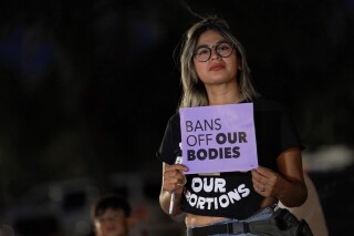 FILE - This file photo shows Celina Washburn at a protest on Sept. 23, 2022, outside the Arizona Capitol in Phoenix to voice her opposition to an abortion ruling. On Tuesday, Dec. 12, 2023, the Arizona Supreme Court heard arguments over whether a pre-statehood ban on nearly all abortions has been repealed or limited by other statutes passed over the last 50 years that regulate the procedure. The court is reviewing a lower-court decision that said doctors couldn’t be charged for performing the procedure in the first 15 weeks of pregnancy because other Arizona laws over the years allow them to carry out abortions. (AP Photo/Matt York, file)