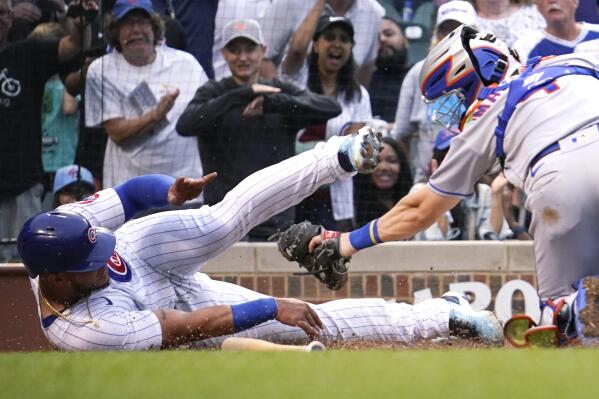 Chicago Cubs' Willson Contreras, left, scores on a single by Nico Hoerner as New York Mets catcher Patrick Mazeika applies a late tag during the eighth inning of a baseball game in Chicago, Sunday, July 17, 2022. The Cubs won 3-2. (AP Photo/Nam Y. Huh)