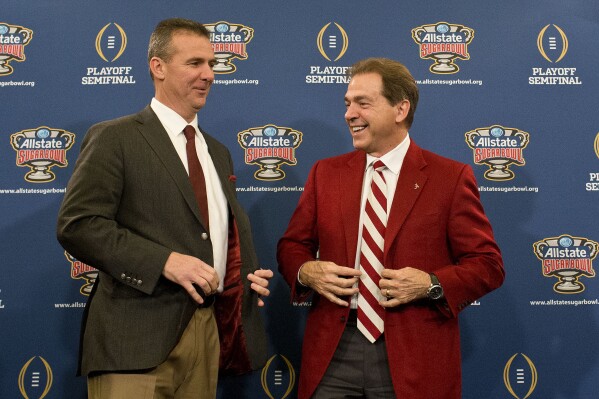 FILE - Ohio State coach Urban Meyer, left, and Alabama coach Nick Saban laugh during a news conference at the Marriott downtown convention center in New Orleans, Dec. 31, 2014. Saban and Meyer are up for election to the College Football Hall of Fame for the first time. (AP Photo/Brynn Anderson, file)