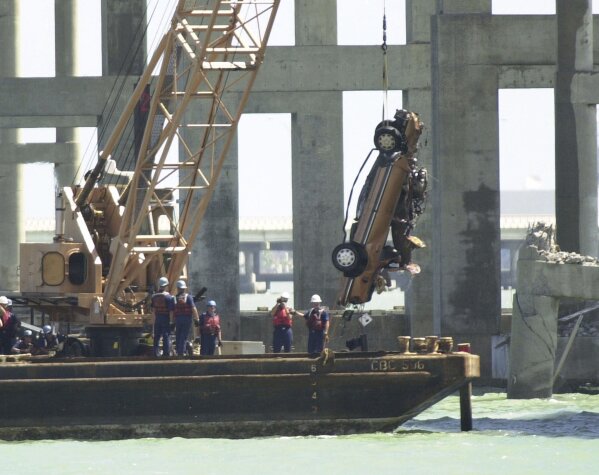 FILE - Recovery workers pull a car from the bay at the site where the Queen Isabella Causeway collapsed, in Port Isabel, Texas, Tuesday, Sept. 18, 2001. The collapse of the Francis Scott Key Bridge in Baltimore following a ship strike on March 26, 2024 brought back jarring memories of their own ordeals to people who survived previous bridge collapses. (AP Photo/Eric Gay, File)