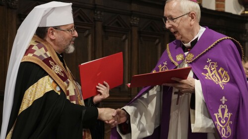 Ukrainos Graikų katalikų bažnyčios arkivyskupas Svjatoslavas Ševčiukas (kairėje) ir Lenkijos Romos katalikų bažnyčios vadovas arkivyskupas Stanislavas Jadeckis (dešinėje) per bendrą religinę apeigą, surengtą per beveik 100 000 lenkų pagerbimo ceremoniją, keičiasi atleidimo ir susitaikymo notomis. 2023 m. liepos 7 d., penktadienį, Varšuvos Šv. Jono katedroje nužudytas ukrainiečių nacionalistų 1943–44 m. (AP nuotr./Czarek Sokolowski)