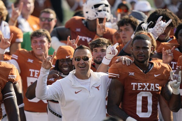 Texas head coach Steve Sarkisian, center, celebrates with his team as they sing the school song after an NCAA college football game against Rice in Austin, Texas, Saturday, Sept. 2, 2023. (AP Photo/Eric Gay)
