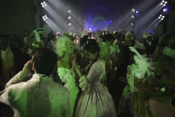 Costumed guests dance at the Great Masked Ball in the Orangerie of the Versailles castle, outside Paris, Sunday, June 22, 2025. (AP Photo/Christophe Ena)