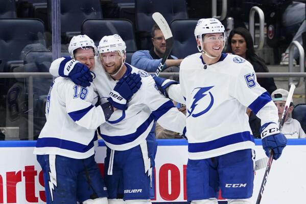 Steven Stamkos (91) celebrates with teammates Ondrej Palat (18) and Cal Foote (52) after scoring a goal during the third period of an NHL hockey game against the New York Islanders, Friday, April 29, 2022, in Elmont, N.Y. (AP Photo/Frank Franklin II)