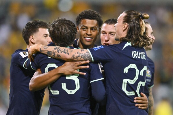 Kusini Yengi of Australia, center, celebrates with teammates after scoring a goal during the Soccer World Cup qualifying match between Lebanon and Australia in Canberra, Australia, Tuesday, March 26, 2024. (AP Photo/Lukas Coch)