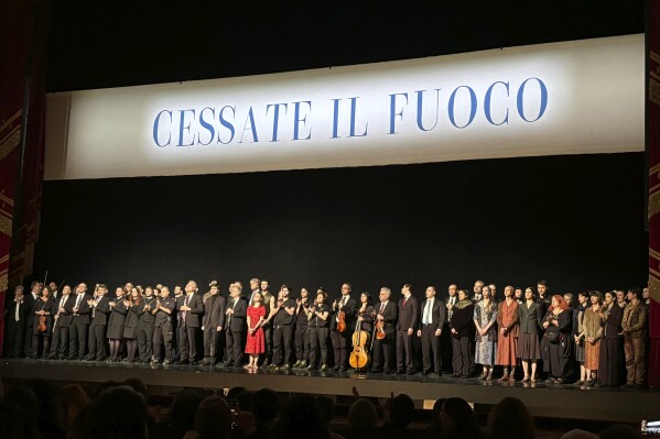 La Scala's dance company and the orchestra stand on stage before the final performance of the opera-ballet 