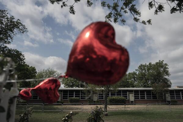 A heart-shaped balloon flies, decorating a memorial site outside Robb Elementary School in Uvalde, Texas. In a town as small as Uvalde, even those who didn't lose their own child lost someone. Some say now that closeness is both their blessing and their curse: they can lean on each other to grieve. But every single one of them is grieving. (AP Photo/Wong Maye-E)