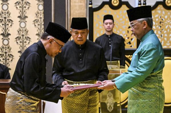 Malaysia's King Sultan Abdullah Sultan Ahmad Shah, right, and newly appointed Prime Minister Anwar Ibrahim, left, take part in the swearing-in ceremony at the National Palace  in Kuala Lumpur, Malaysia, Thursday, Nov. 24, 2022. Malaysia's king on Thursday named Anwar as the country's prime minister, ending days of uncertainty after the divisive general election produced a hung Parliament. (Mohd Rasfan/Pool Photo via AP)