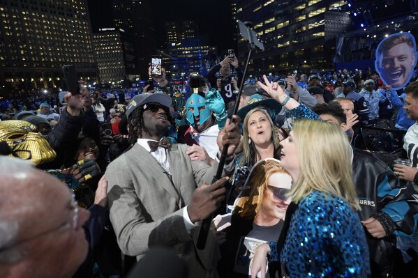 LSU wide receiver Brian Thomas Jr. celebrates with fans after being chosen by the Jacksonville Jaguars with the 23rd overall pick during the first round of the NFL football draft, Thursday, April 25, 2024, in Detroit. (AP Photo/Paul Sancya)