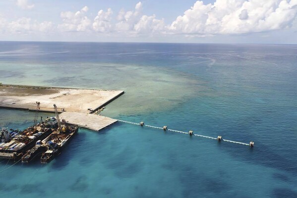 FILE - In this photo provided by the Department of National Defense PAS, ships carrying construction materials are docked at the newly built beach ramp at the Philippine-claimed island of Pag-asa, also known as Thitu, in the disputed South China Sea on June 9, 2020. The Philippine coast guard inaugurated a new monitoring base Friday, Dec. 1, 2023, on a remote island occupied by Filipino forces in the disputed South China Sea as Manila ramps up efforts to counter China鈥檚 increasingly aggressive actions in the strategic waterway. (Department of National Defense PAS via AP, File)