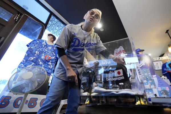 Hironobu Kanno, representative of a private fan club of Shohei Ohtani of the Los Angeles Dodgers, shows his collection items at his beauty salon in Oshu, northeastern Japan, the hometown of Ohtani, Tuesday, Oct. 29, 2024. (AP Photo/Eugene Hoshiko)