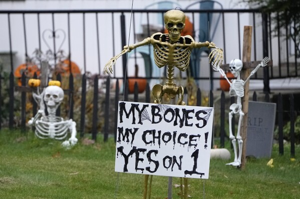 A sign urging a vote for a constitutional amendment seeking to protect abortion rights in Ohio is incorporated into a Halloween decoration display, Monday, Oct. 30, 2023, in Broadview Heights, Ohio. (AP Photo/Sue Ogrocki)