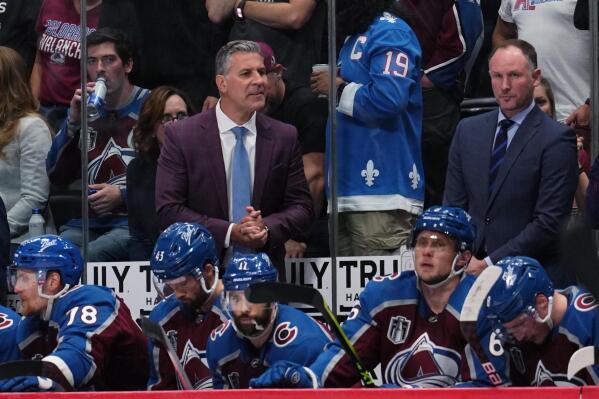 Colorado Avalanche coach Jared Bednar stands behind players on the bench during the third period in Game 5 of the team's NHL hockey Stanley Cup Final against the Tampa Bay Lightning, Friday, June 24, 2022, in Denver. (AP Photo/Jack Dempsey)