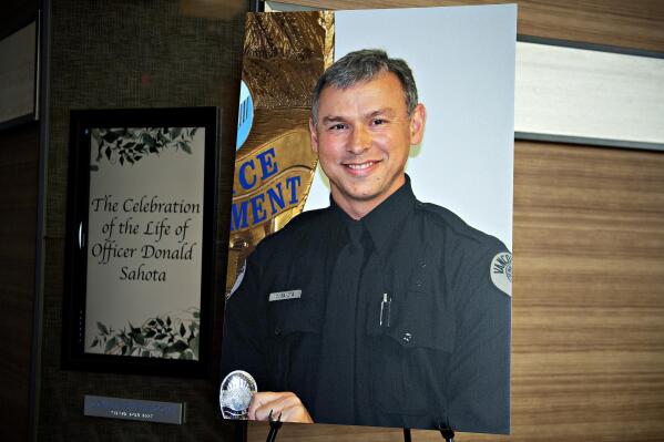 FILE- A portrait of Officer Vancouver Police Department officer Donald Sahota is displayed as he is honored by friends, family and colleagues at ilani Casino Resort near La Center, Wash., on Feb. 8, 2022. Sahota, 52, was mistakenly shot at his home near Battle Ground by a Clark County sheriff during a manhunt for a robbery suspect. Julio Segura, 20,  who was being chased when a sheriff’s deputy mistakenly shot and killed off-duty police officer Donald Sahota on Jan. 29, 2022, pleaded not guilty on Tuesday, March 1, 2022, to multiple charges including murder. (Amanda Cowan/The Columbian via AP, File)