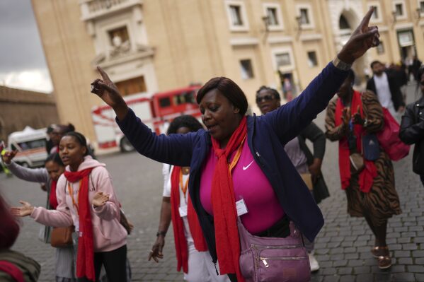 Group of faithful from France chant religious songs as they arrive at St. Peter's Square at the Vatican where 133 cardinals gather on the second day of the conclave to elect successor of late Pope Francis, Thursday, May 8, 2025. (AP Photo/Francisco Seco)