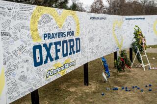 FILE - Handwritten messages are left at the memorial site at the memorial site on Tuesday, Dec. 7, 2021, outside Oxford High School in Oxford, Mich., after a 15-year-old allegedly killed these four classmates, and injured seven others in a shooting inside the northern Oakland County school one week earlier. School officials around the country are planning to step up security Friday in response to social media posts warning of violence. The anonymous threats on TikTok had many educators on edge because they are circulating in the aftermath of a deadly school shooting in Michigan.  (Jake May/The Flint Journal via AP, File)