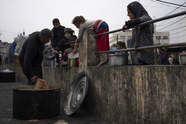 Palestinians line up for free food in Rafah, Gaza Strip, Friday, Feb. 23, 2024. An estimated 1.5 million Palestinians displaced by the war took refuge in Rafahor, which is likely Israel's next focus in its war against Hamas.(AP Photo/Fatima Shbair)