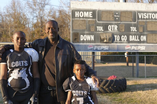 This photo provided by the University of Maryland shows Ronald Redmond standing with sons, 11-year-old R.J., left, and 7-year-old Mason on a football field in Lexington, Mississippi, Jan. 4, 2024. Lexington, Miss. is located in the second-poorest county in the nation鈥檚 poorest state. Yet a new analysis shows the town sends more players per capita to elite college football programs than any other town in Mississippi 鈥� at a rate that鈥檚 among the top in the nation. For many families, the game offers hope for college and a future. (University of Maryland/Jenna Bloom via 麻豆传媒app)