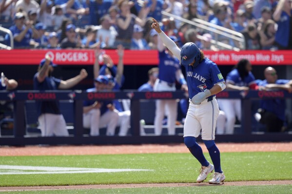Toronto Blue Jays shortstop Bo Bichette (11) celebrates after scoring on a two-run home run by teammate Daulton Varsho during the second inning of a baseball game against the Chicago White Sox in Toronto, Monday, May 20, 2024. (Chris Young/The Canadian Press via AP)